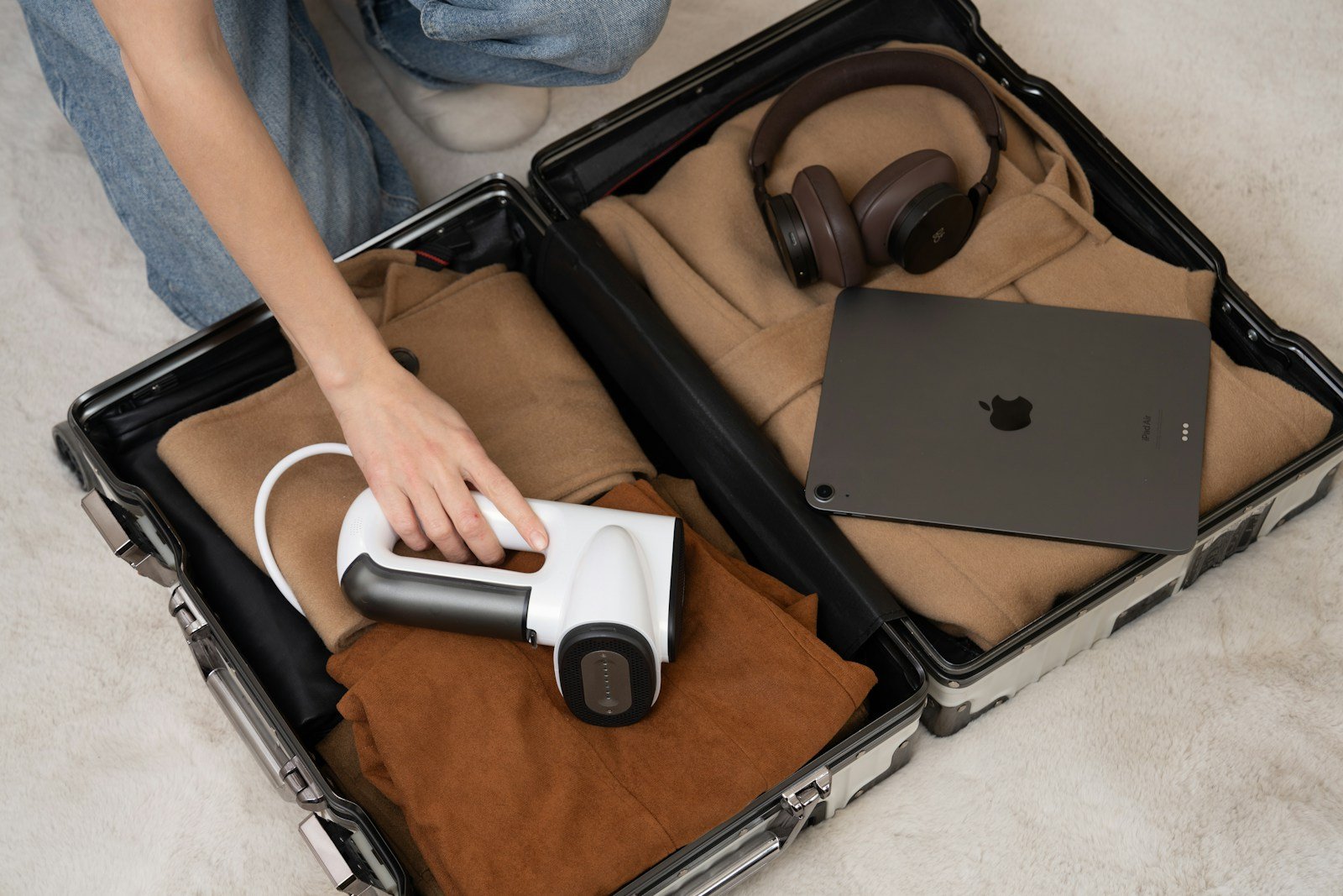 A person sitting on the floor with a laptop in a suit case